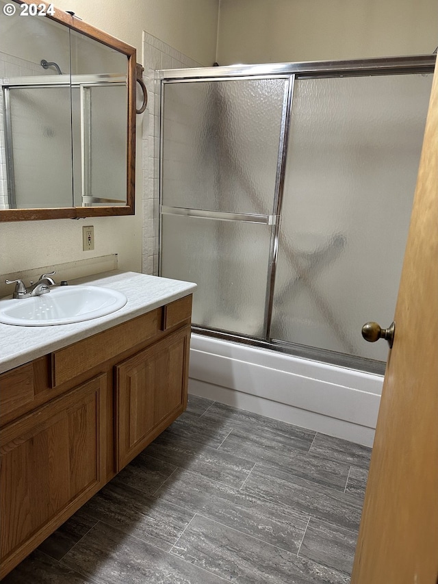 bathroom with vanity and combined bath / shower with glass door