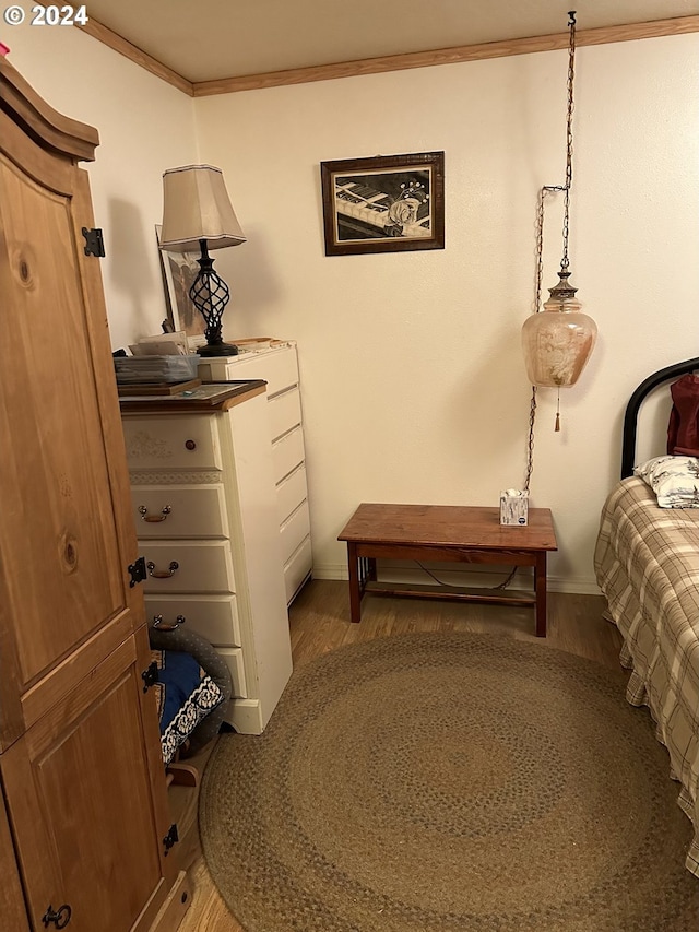 bedroom with ornamental molding and wood-type flooring