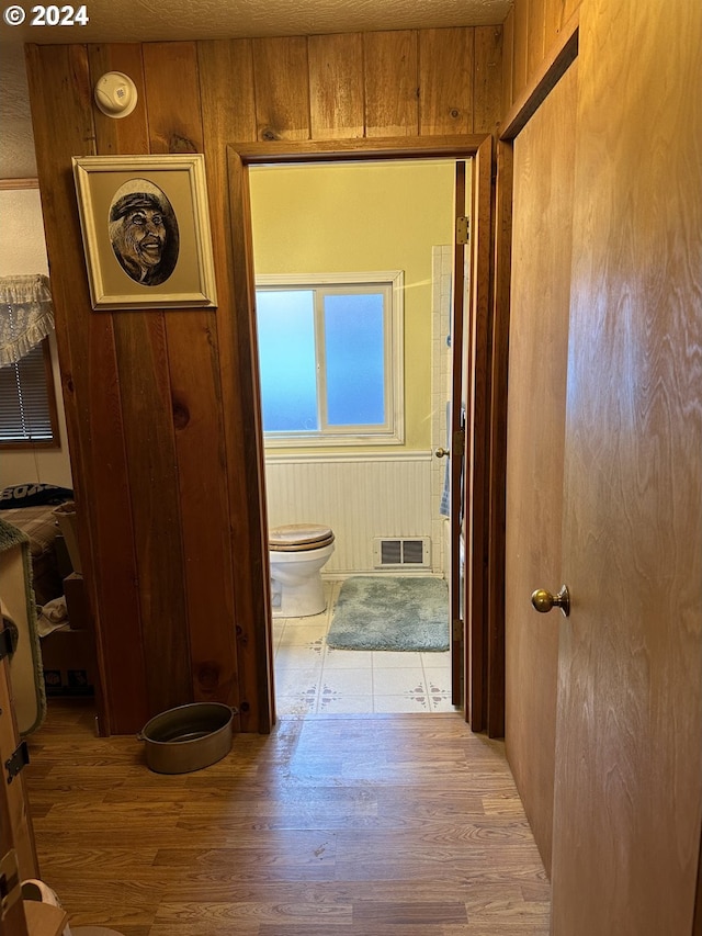 corridor with wood walls and hardwood / wood-style flooring