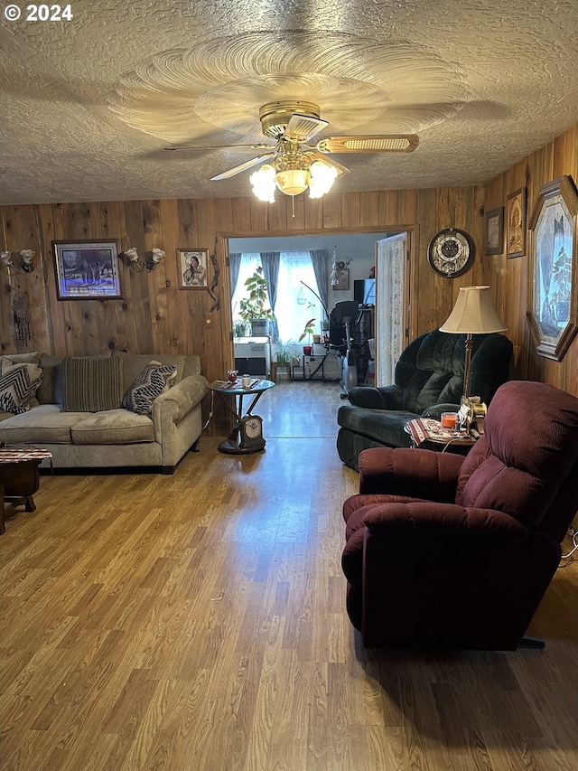 136350 Main St, Crescent, OR 97733 - living room featuring wooden walls, a ceiling fan, a textured ceiling, and wood finished floors