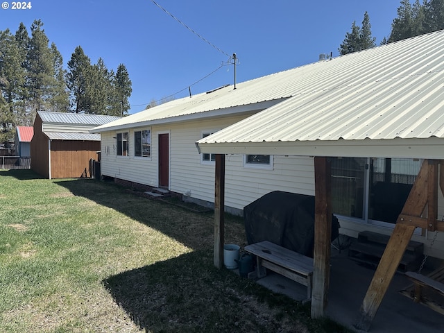 exterior space with a lawn and a storage shed