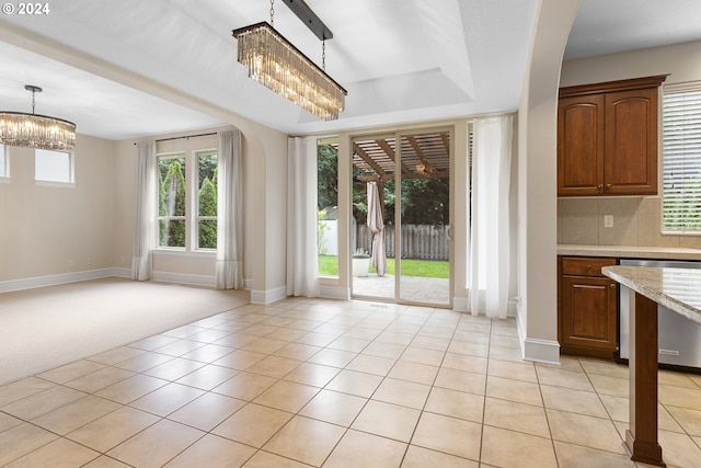 unfurnished dining area featuring a chandelier and light tile patterned flooring