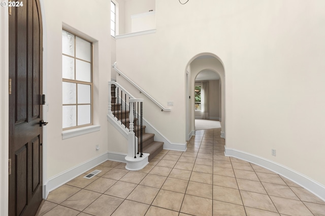 tiled entryway featuring a towering ceiling