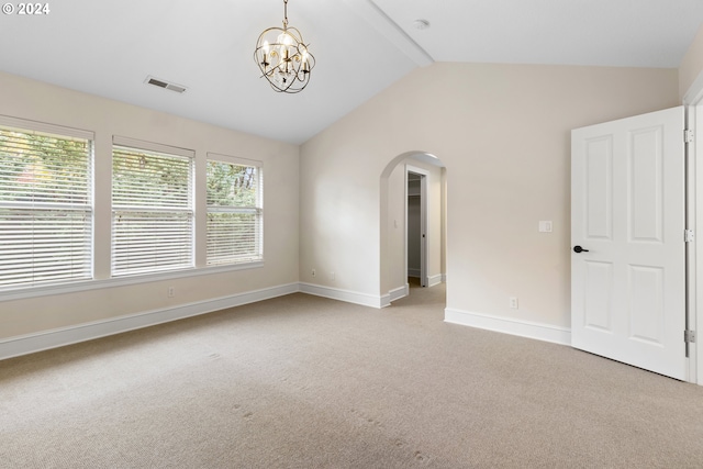 empty room featuring lofted ceiling with beams, light carpet, and a notable chandelier