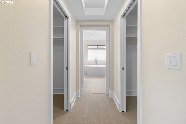 hallway featuring light colored carpet