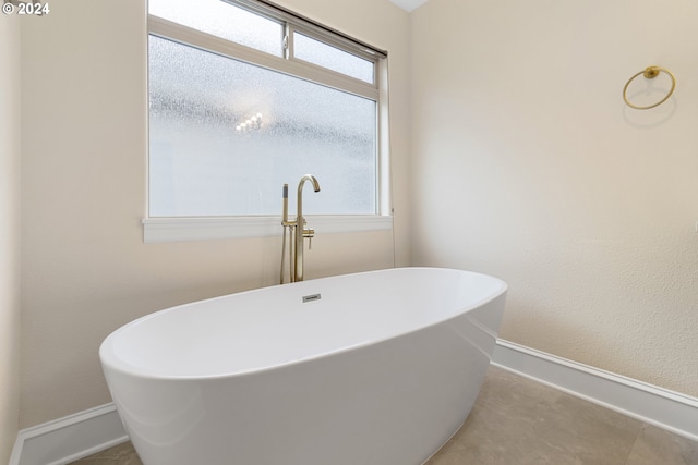 bathroom featuring a tub to relax in and a wealth of natural light