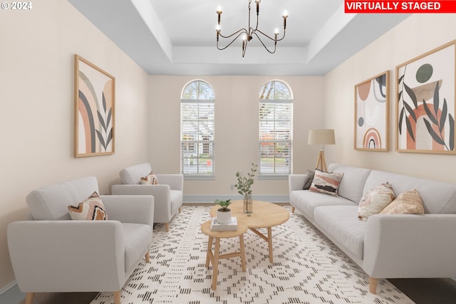 living room featuring a raised ceiling and an inviting chandelier