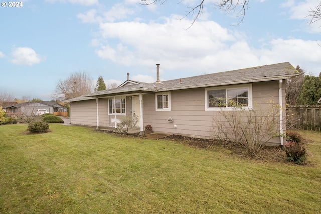 rear view of property with a yard