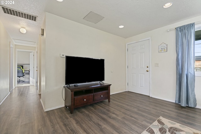 living room with dark hardwood / wood-style floors and a textured ceiling