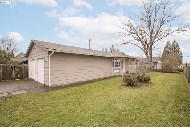 rear view of property with a garage and a yard