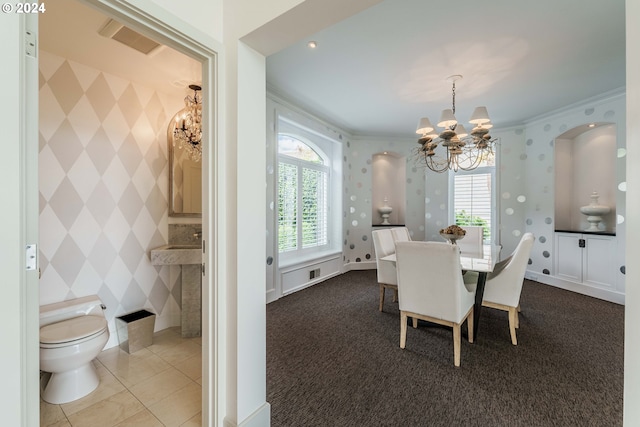 dining area with carpet flooring, ornamental molding, and a notable chandelier