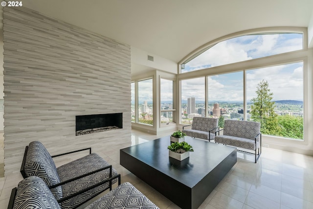 living room featuring a large fireplace, light tile patterned floors, and a wealth of natural light