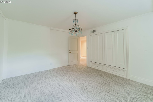 unfurnished bedroom featuring a closet, crown molding, light carpet, and a chandelier