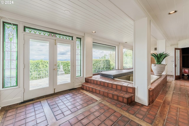 doorway featuring french doors, dark tile patterned floors, and wooden ceiling