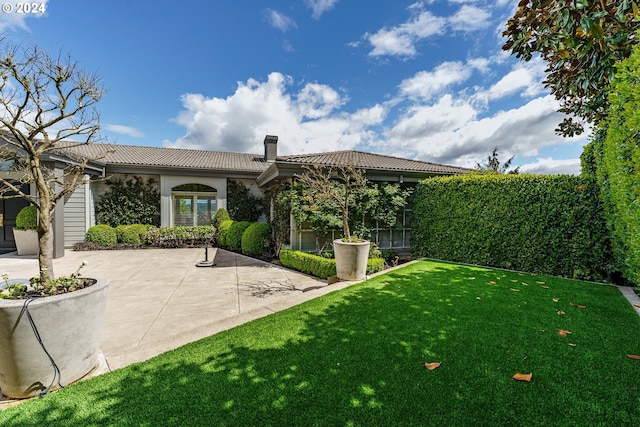 back of property featuring a patio and a lawn