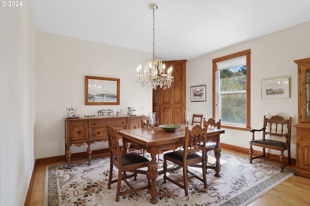 dining room with light wood-type flooring and a chandelier