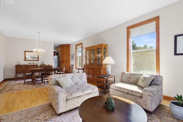 living room with light wood-type flooring and a chandelier