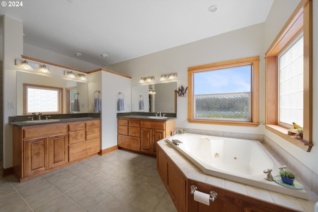 bathroom featuring tiled bath, vanity, and tile patterned flooring