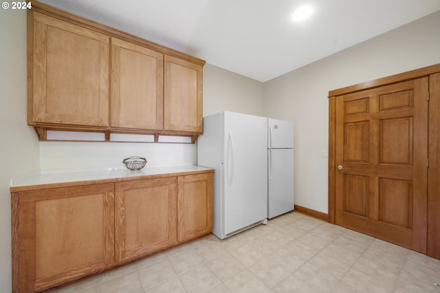 kitchen featuring tile counters and white fridge