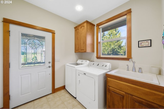 washroom with cabinets, separate washer and dryer, and sink