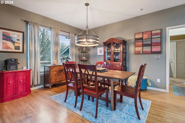 dining space featuring light hardwood / wood-style floors and an inviting chandelier