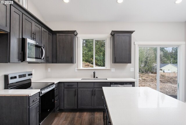 130 E H St, Vernonia, OR 97064 - kitchen with appliances with stainless steel finishes, a sink, recessed lighting, dark wood-type flooring, and light countertops