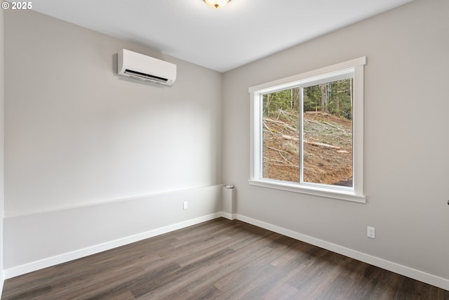 130 E H St, Vernonia, OR 97064 - unfurnished room with an AC wall unit, dark wood-style flooring, and baseboards