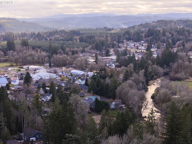 130 E H St, Vernonia, OR 97064 - aerial overview of property's location with a mountainous background and a forest