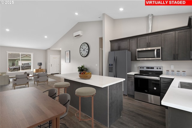 130 E H St, Vernonia, OR 97064 - kitchen featuring appliances with stainless steel finishes, a center island, light countertops, dark wood-style flooring, and high vaulted ceiling