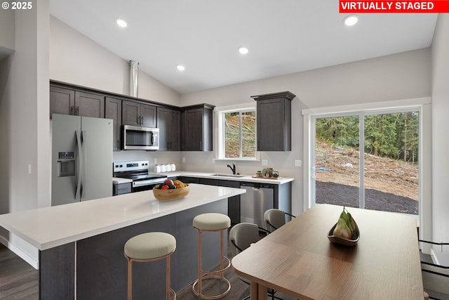 130 E H St, Vernonia, OR 97064 - kitchen with stainless steel appliances, a sink, lofted ceiling, a kitchen island, and light countertops
