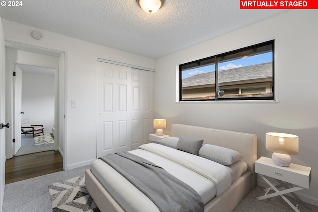 bedroom featuring hardwood / wood-style flooring, a textured ceiling, and a closet