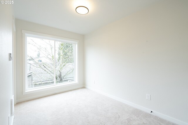 unfurnished room with light colored carpet