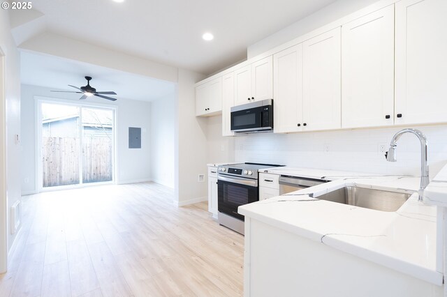 kitchen with white cabinets, sink, decorative backsplash, light stone countertops, and stainless steel appliances