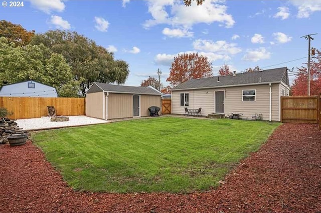 back of house featuring a patio area, a yard, an outdoor fire pit, and a shed