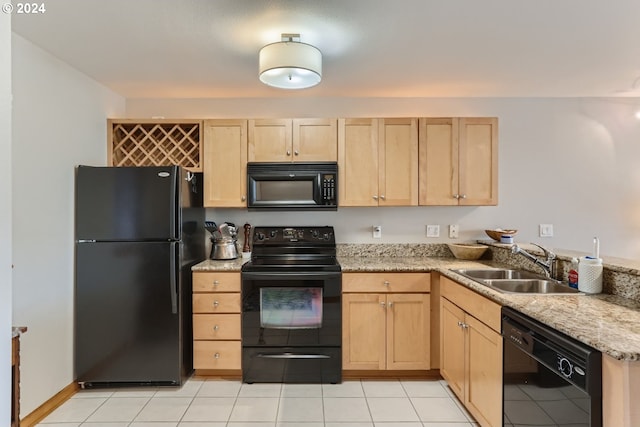 kitchen with black appliances, light brown cabinetry, and sink