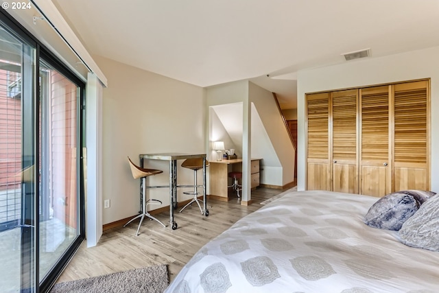 bedroom with light wood-type flooring, a closet, and access to outside