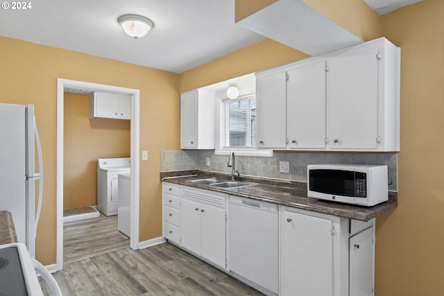 kitchen featuring sink, white cabinets, light hardwood / wood-style floors, and white appliances