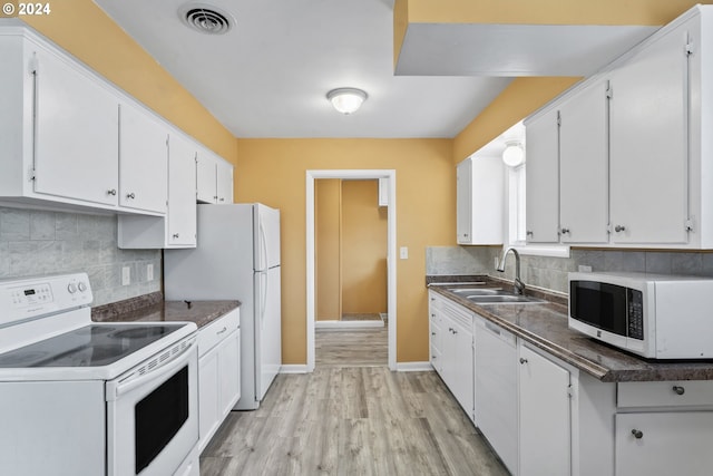 kitchen featuring white cabinets and white appliances