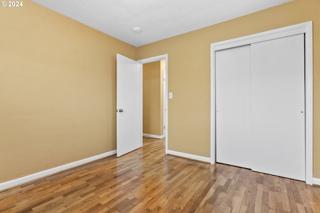 unfurnished bedroom featuring light hardwood / wood-style flooring and a closet