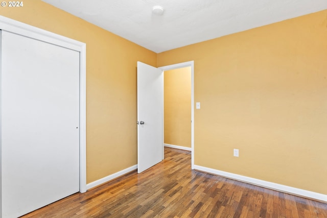 unfurnished bedroom featuring hardwood / wood-style flooring and a closet