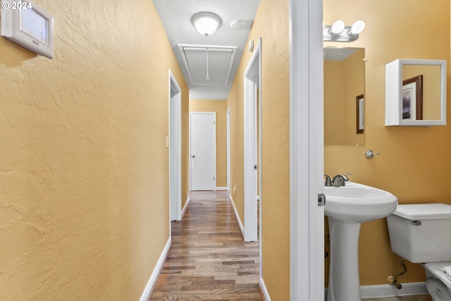 hallway with light hardwood / wood-style floors and sink