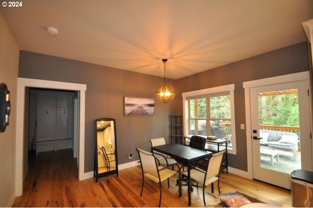 dining room with wood-type flooring and a notable chandelier