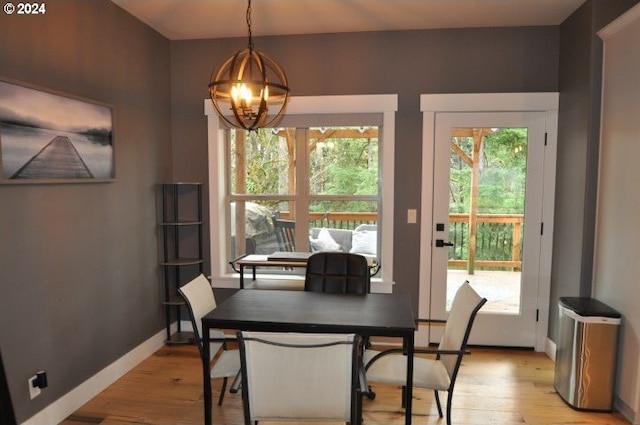 dining room with light wood-type flooring and an inviting chandelier