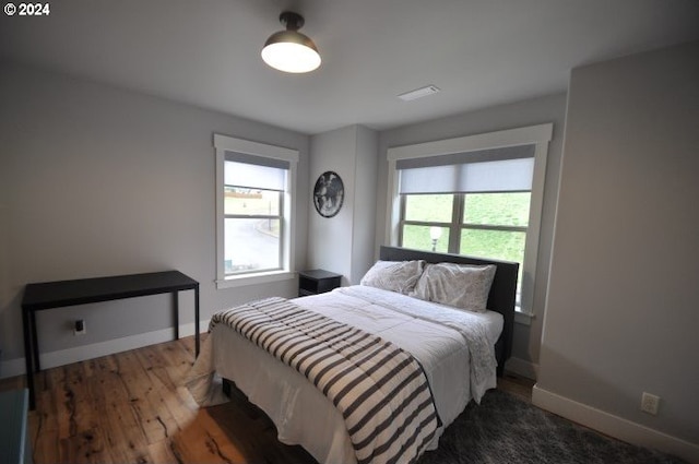 bedroom with dark hardwood / wood-style floors