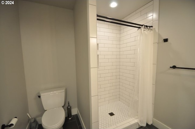 bathroom with tile patterned flooring, toilet, and curtained shower