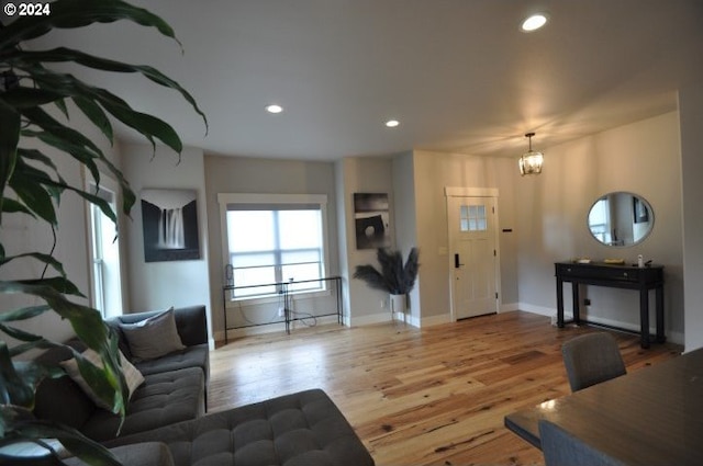 living room with light hardwood / wood-style floors and an inviting chandelier