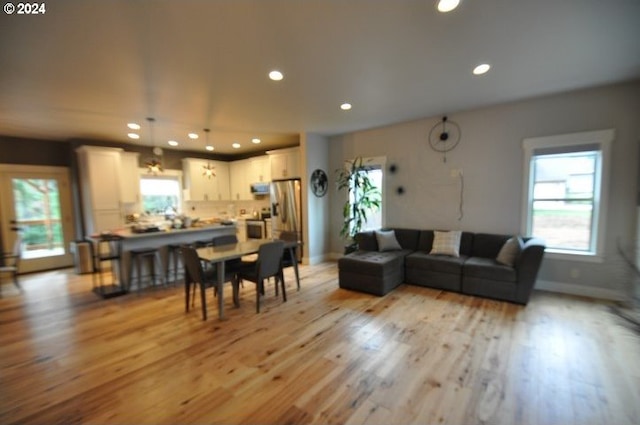 living room featuring a wealth of natural light and light hardwood / wood-style flooring