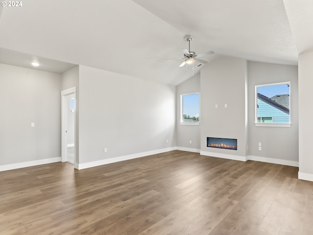 unfurnished living room featuring ceiling fan, lofted ceiling, hardwood / wood-style floors, and a wealth of natural light