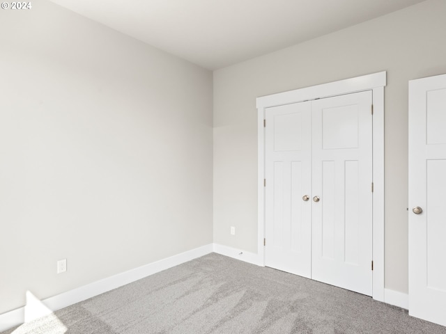 unfurnished bedroom featuring a closet and carpet flooring