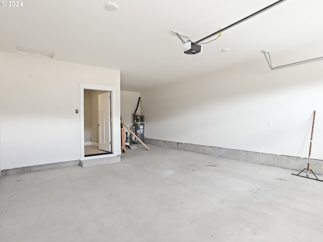 garage with strapped water heater and a garage door opener